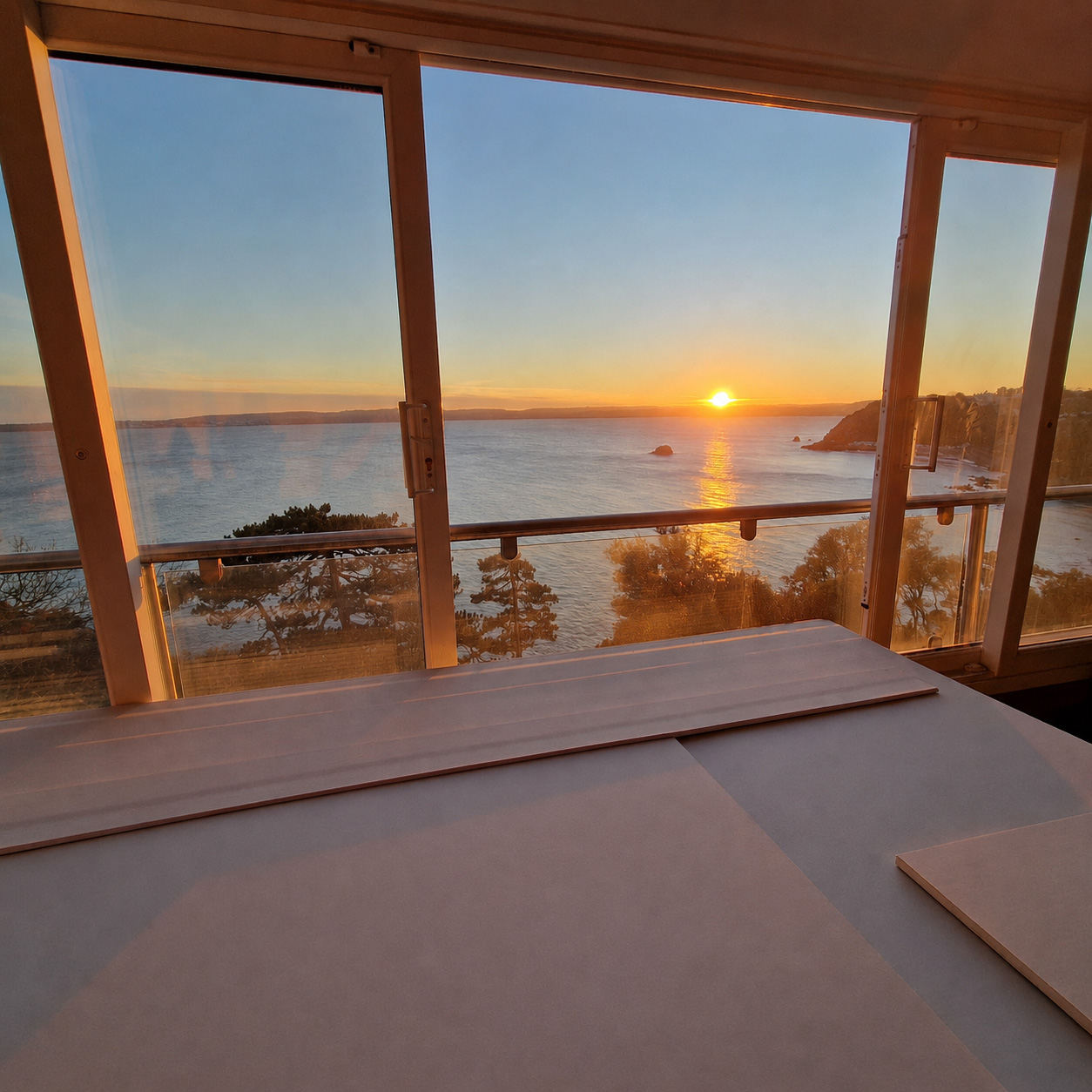 Sunset sea view from renovated coastal property with new sliding doors in South Devon